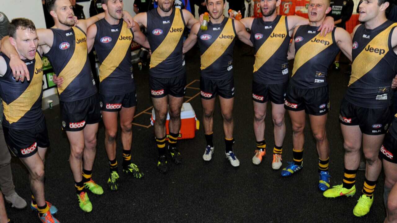 Richmond Tigers player sing the club song in the dressing room.