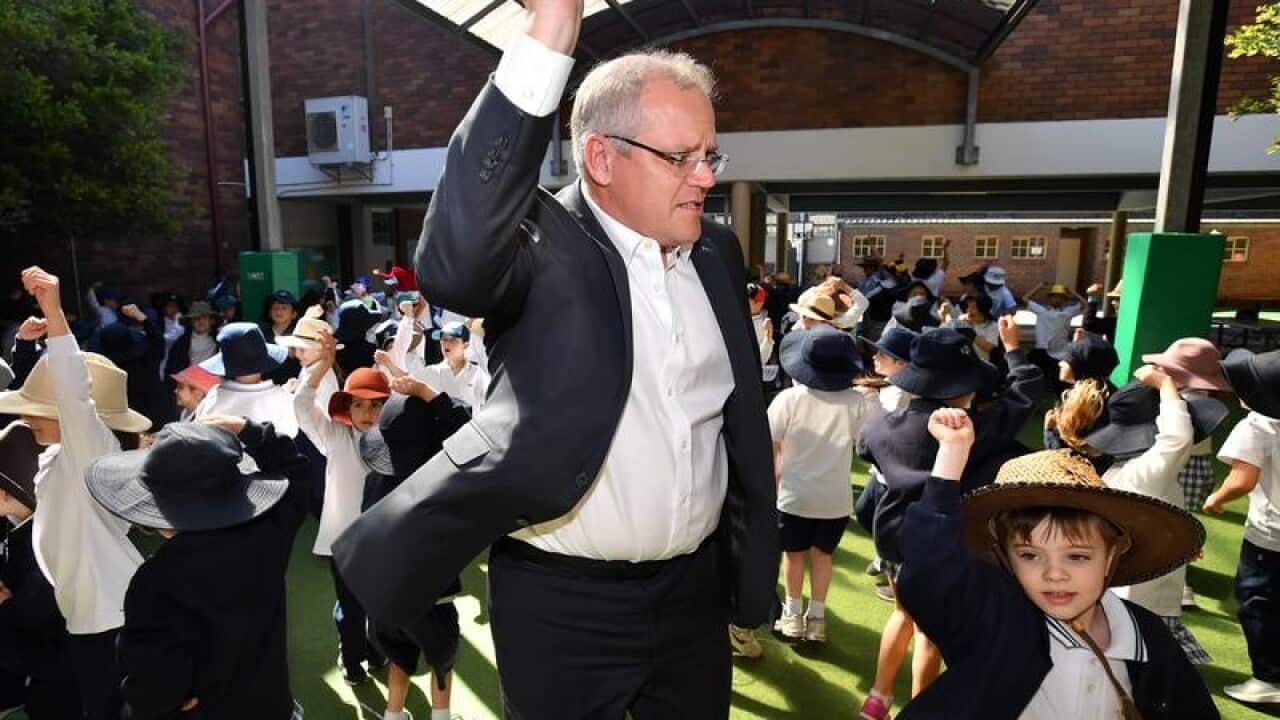 Prime Minister Scott Morrison dances with students.