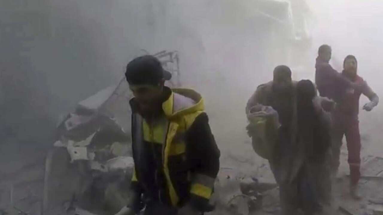 Members of Syria's White Helmets rescue group help residents