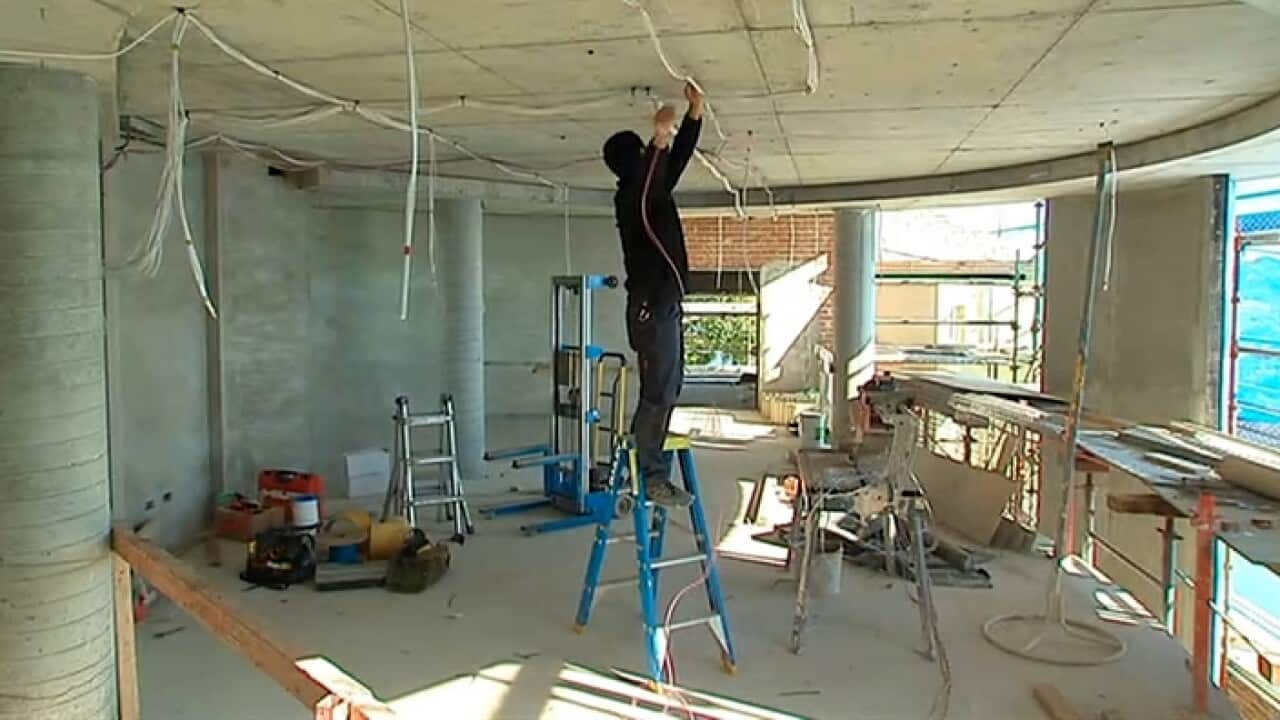 A migrant worker installing electrical circuits (SBS).