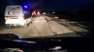 An image grab from a handout video shows a Red Crescent ambulance with its emergency lights flashing as it drives toward a fire truck and other ambulances