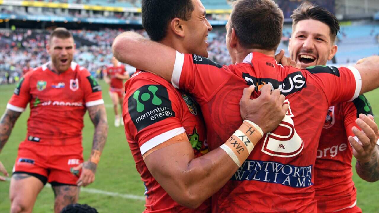 Jason Nightingale (centre) of the Dragons is congratulated