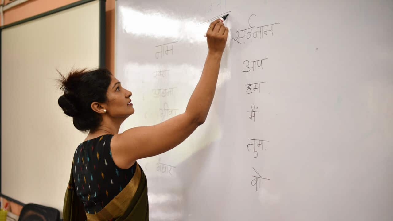 Teacher teaching and writing on board