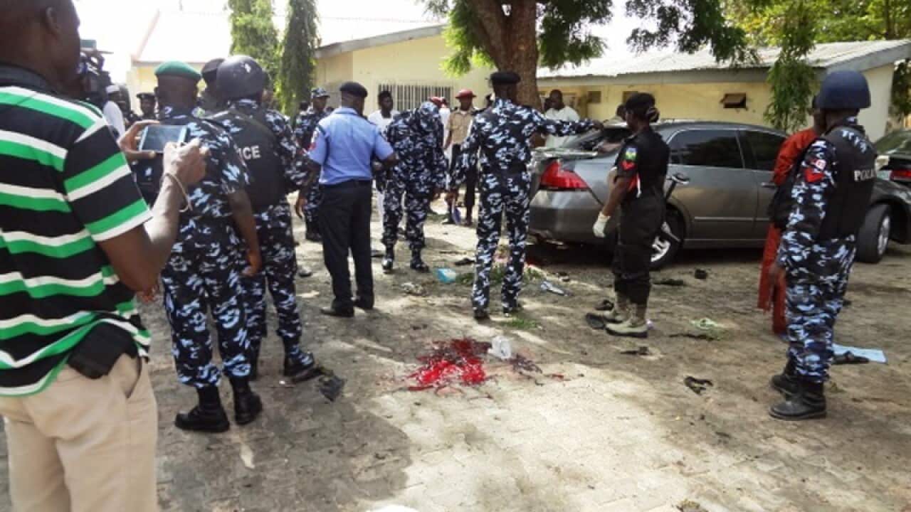 Policemen stand at the scene of a bomb blast