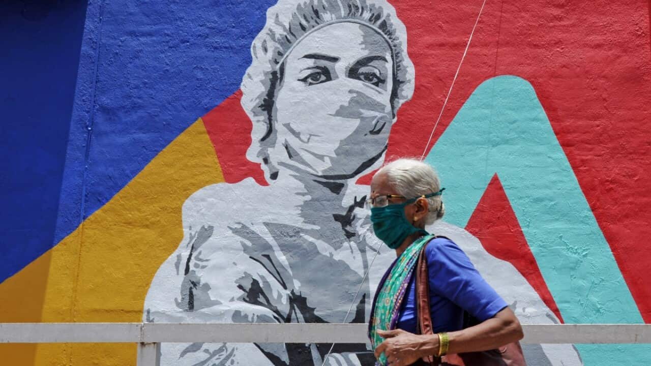 An elderly woman walks past a graffiti of coronavirus warrior in Mumbai. Mural depicts a nurse as one of the many corona warriors who have worked throughout the lockdown, exposing themselves to the risk of infection. It is the expression of what every cit