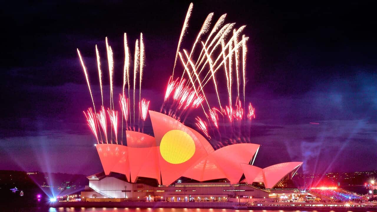 Fireworks are seen as the Aboriginal flag is projected onto the sails of the Sydney Opera House during Australia Day celebrations.