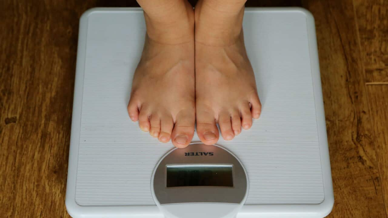 A person being weighed on scales