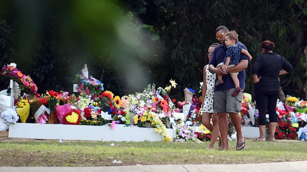 Mourners visit the burial site of eight children