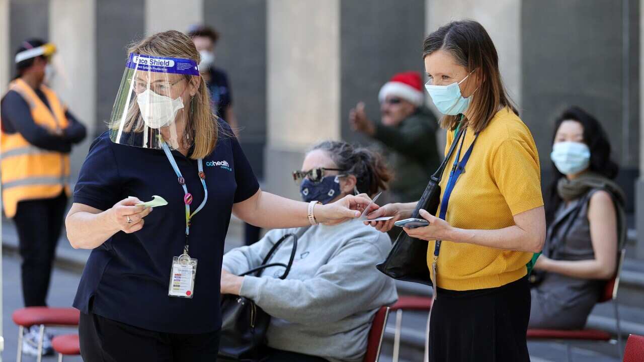 People are seen at a Cohealth pop-up vaccination clinic at the State Library Victoria, in Melbourne, Monday, December 20, 2021
