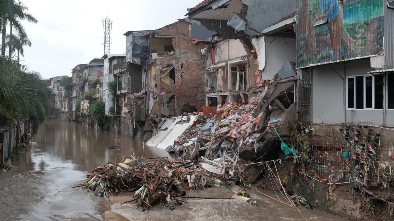 A person cleans up their shop after a flood.