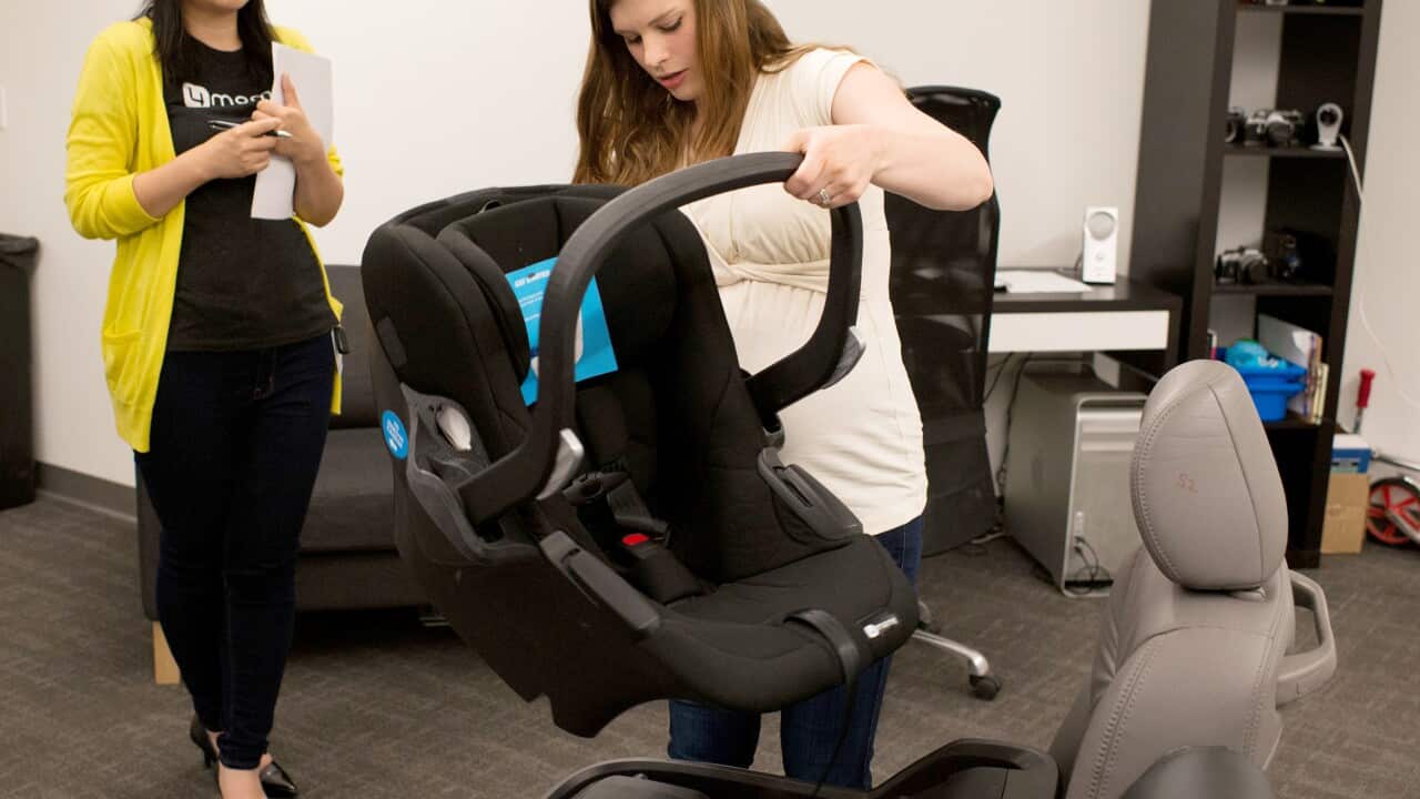 Deseree Younes takes the carrier portion of a prototype infant car seat off an auto seat at 4moms, Pittsburgh on May 27, 2015. (Joe Appel/The Washington Post)