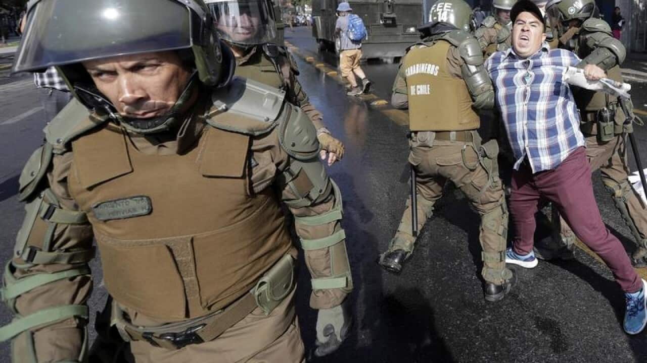 A man is arrested during a protest against Pope Francis