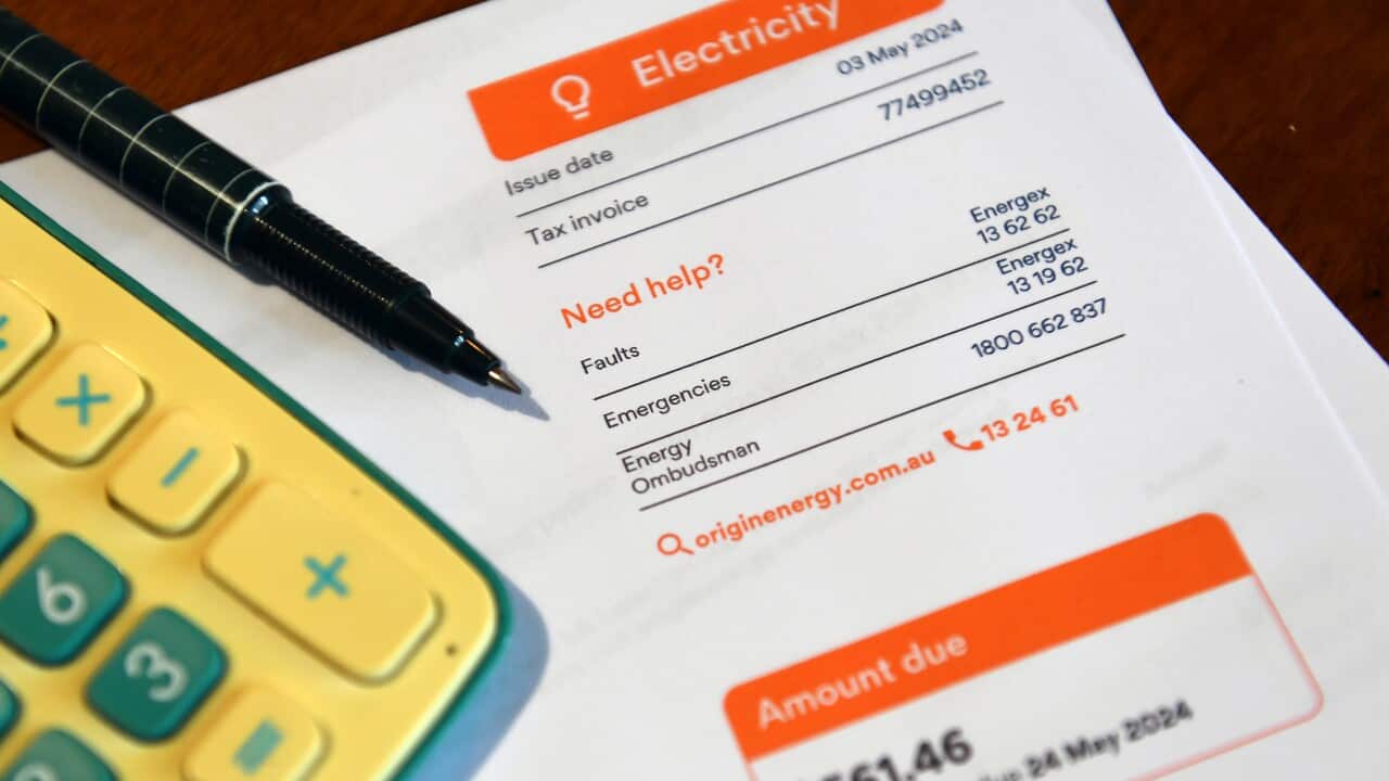 A residential electricity bill with a pen and a calculator on top it.