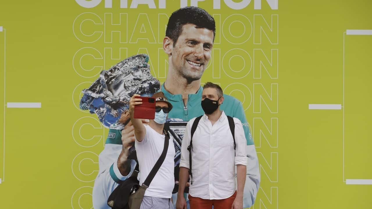 People take a selfie with a photo of Novak Djokovic at the Australian Open tennis championships in Melbourne