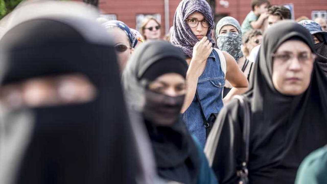 Demonstrators cover their faces during a protest in Copenhagen, Denmark, 01 August 2018, on the first day of the implementation of the Danish face veil ban.