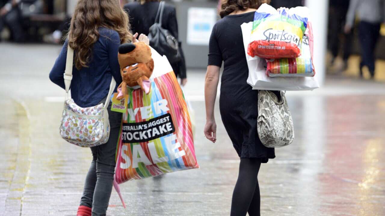 Women carry shopping bags.
