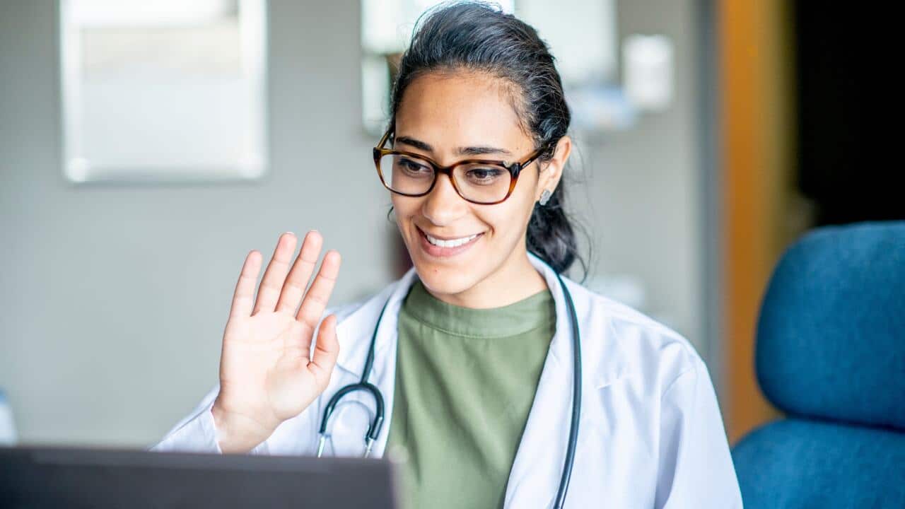 Female doctor waving to telehealth