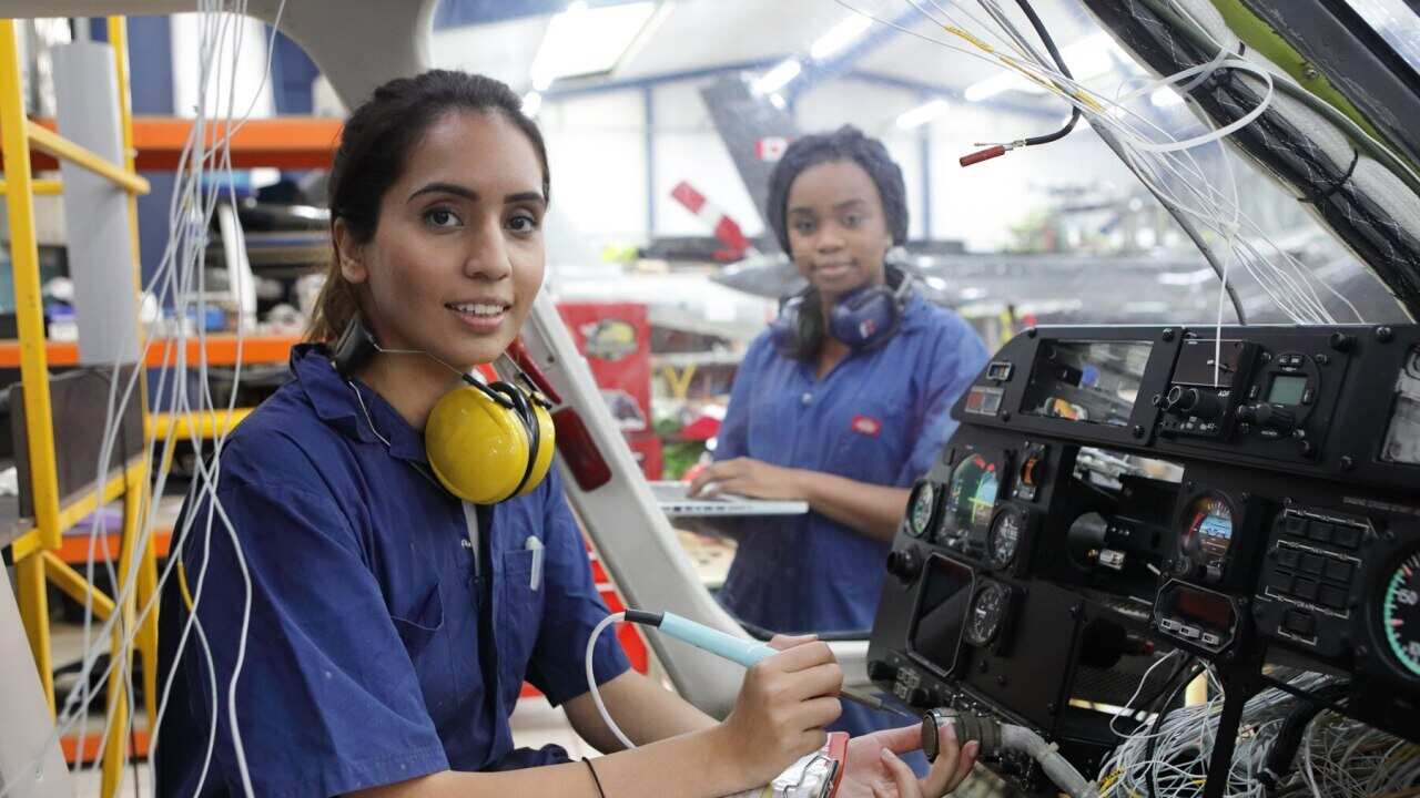 Young female engineers working with helicopters