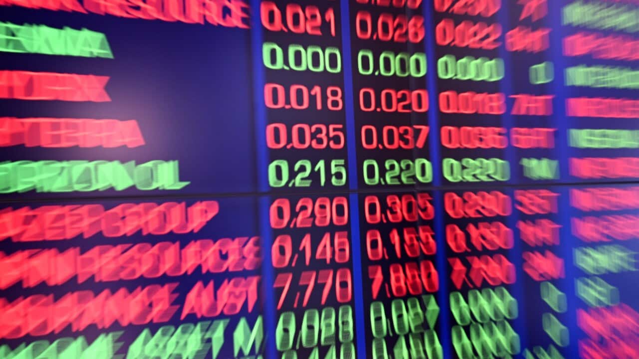 Stock exchange figures are displayed on a screen.