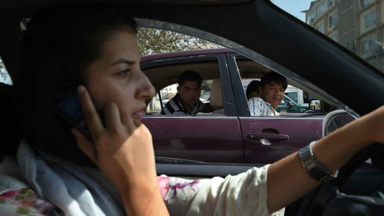 In this photograph taken on September 4, 2015, Afghan woman, Rokhsar Azamee, 23, drives her car as Afghan youths stare at her in the streets of Kabul. — AFP