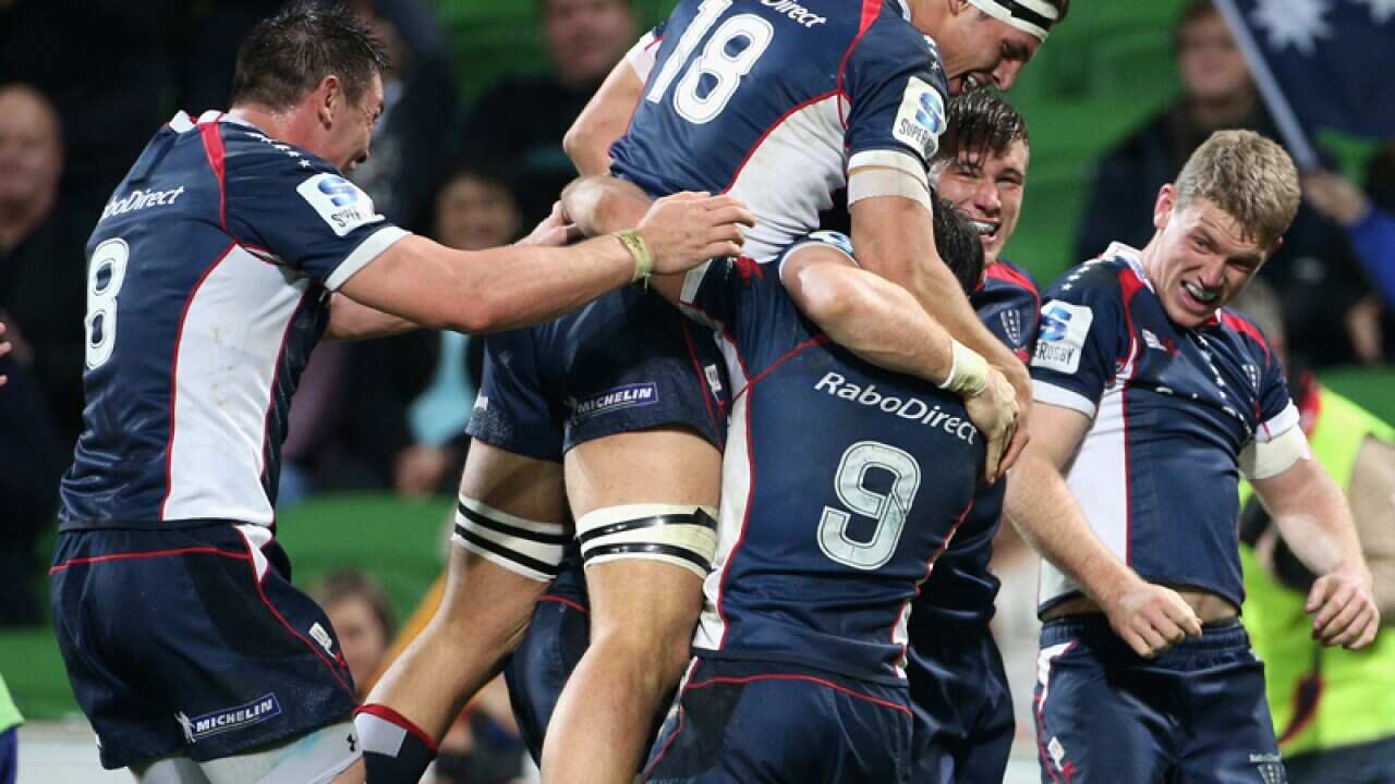 Melbourne Rebels players celebrate scoring a try