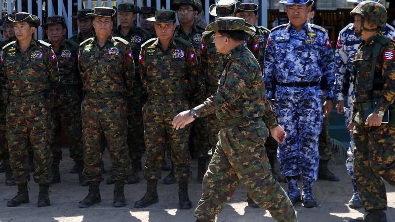 Min Aung Hlaing walks in front of high-ranking military officers