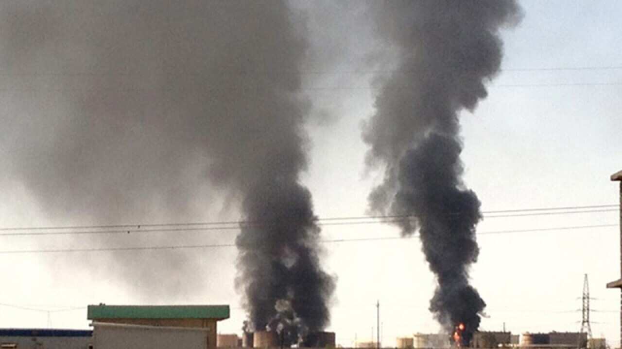 Smoke rises from an oil refinery following clashes in Iraq.