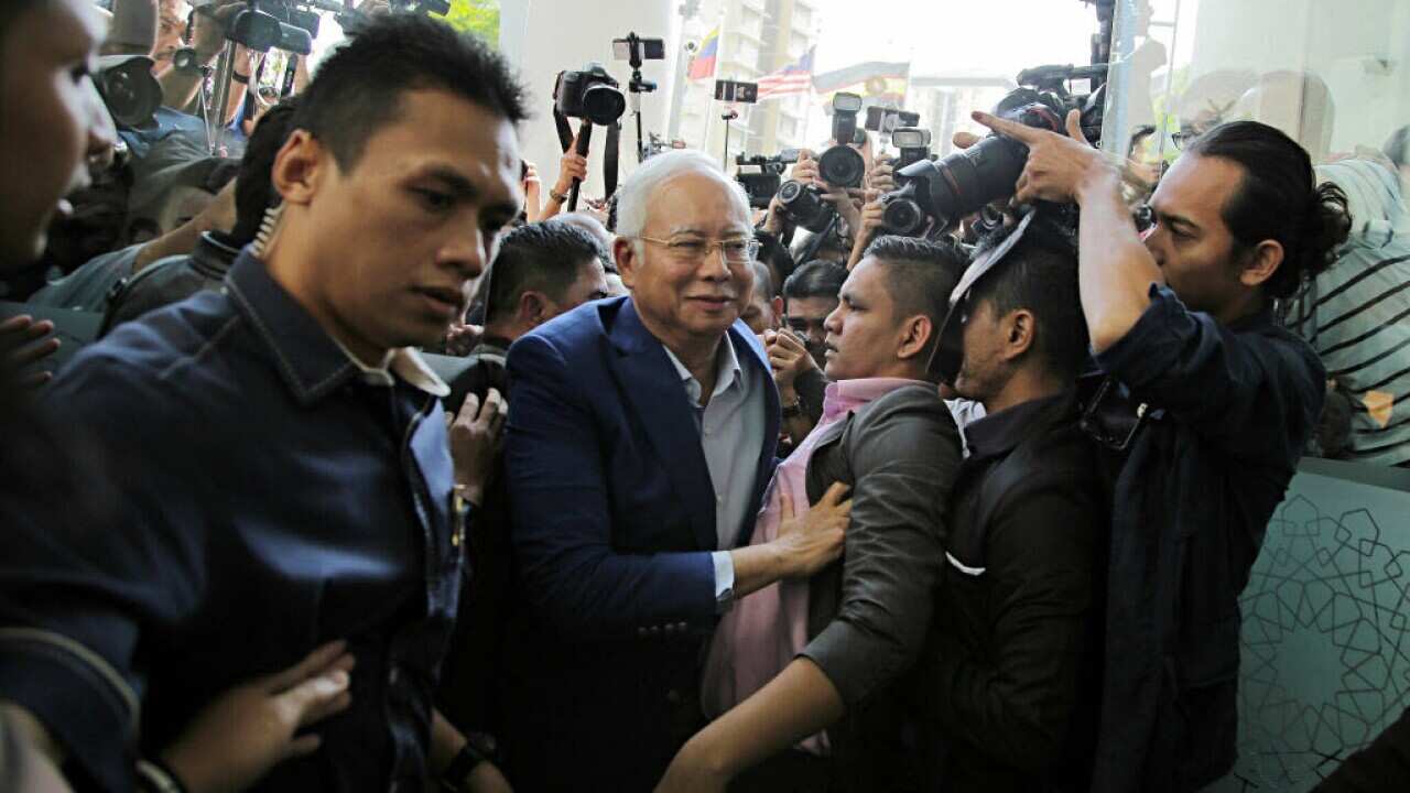 Najib Razak, Malaysia's former prime minister, center, surrounded by media as he arrives at the Malaysian Anti-Corruption Commission's headquarters.