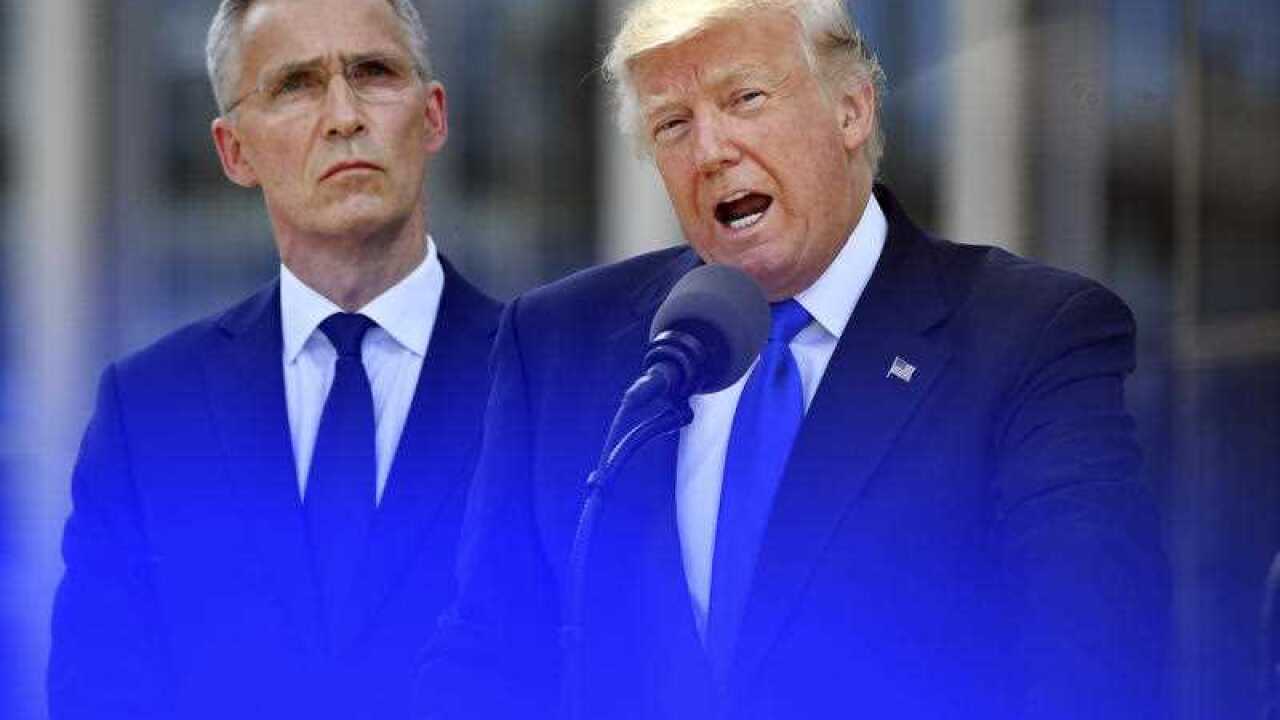 U.S. President Donald Trump, right, speaks as NATO Secretary General Jens Stoltenberg looks on during ceremony at NATO headquarters