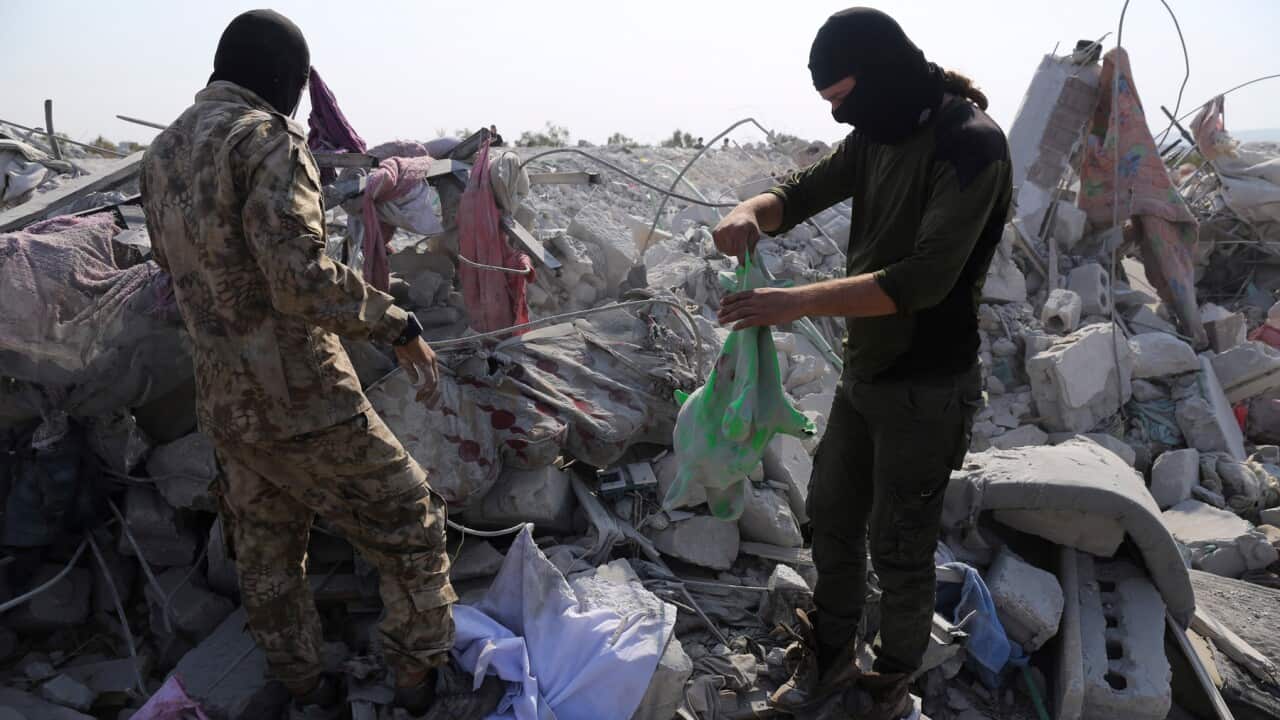 People look at a destroyed house in Idlib province after the US operation targeting Abu Bakr al-Baghdadi