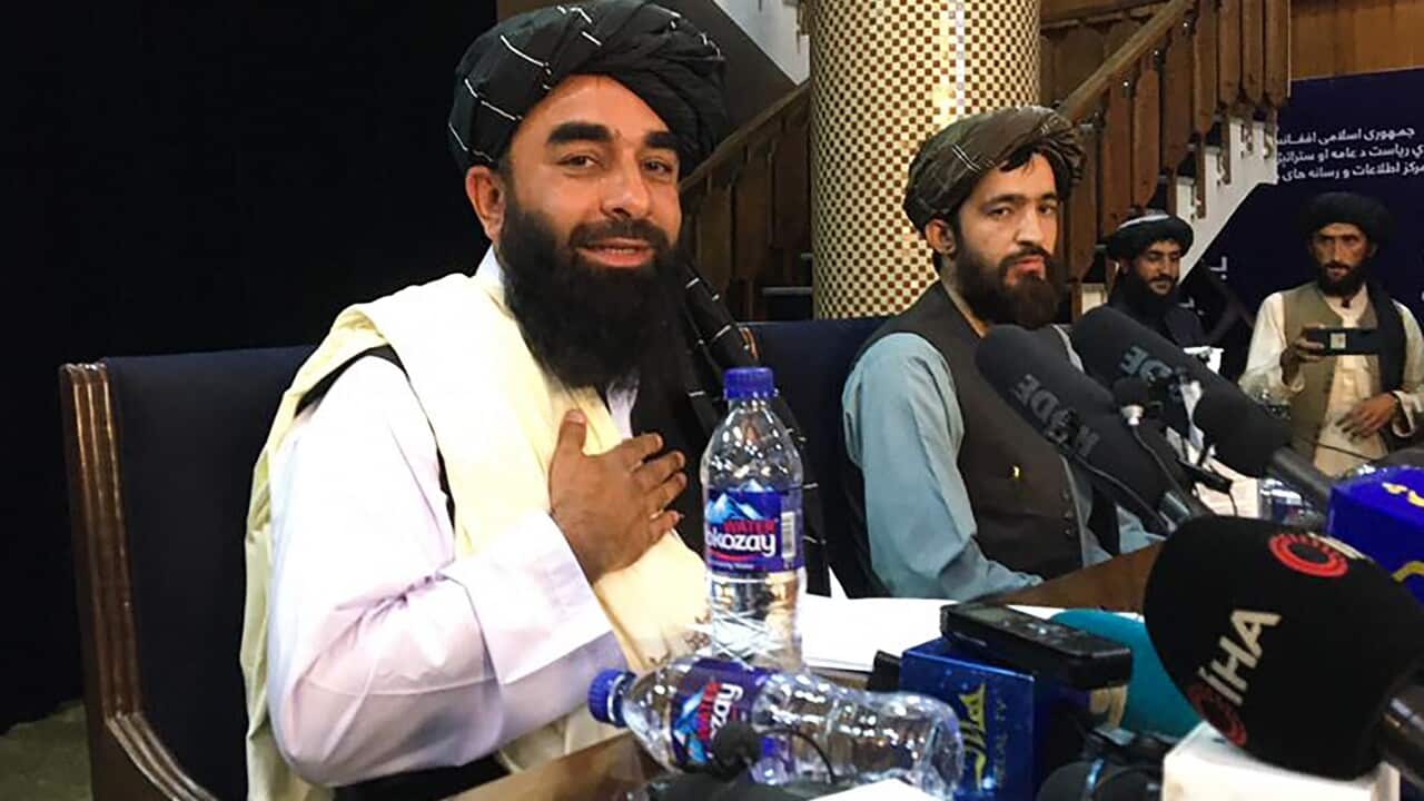 Taliban spokesperson Zabihullah Mujahid (L) attends the first press conference in Kabul