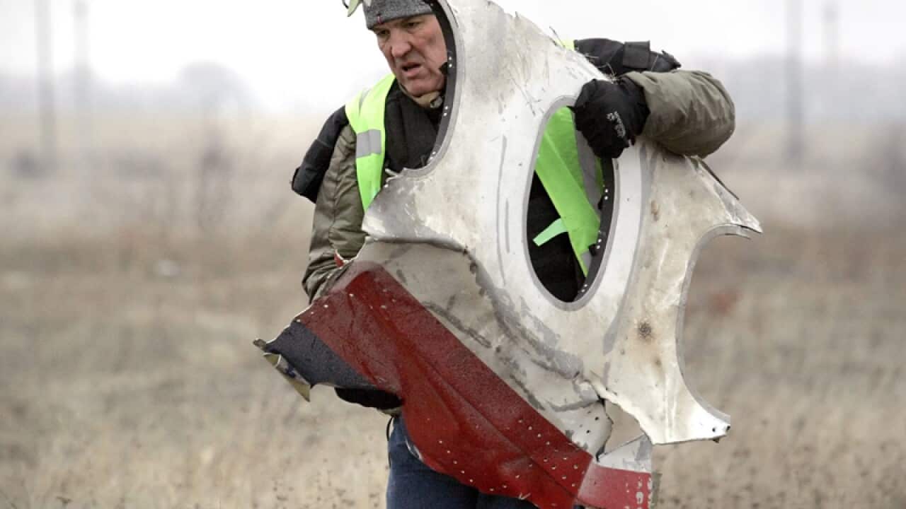 A worker removes a part of the wreckage of Malaysia Airlines MH17