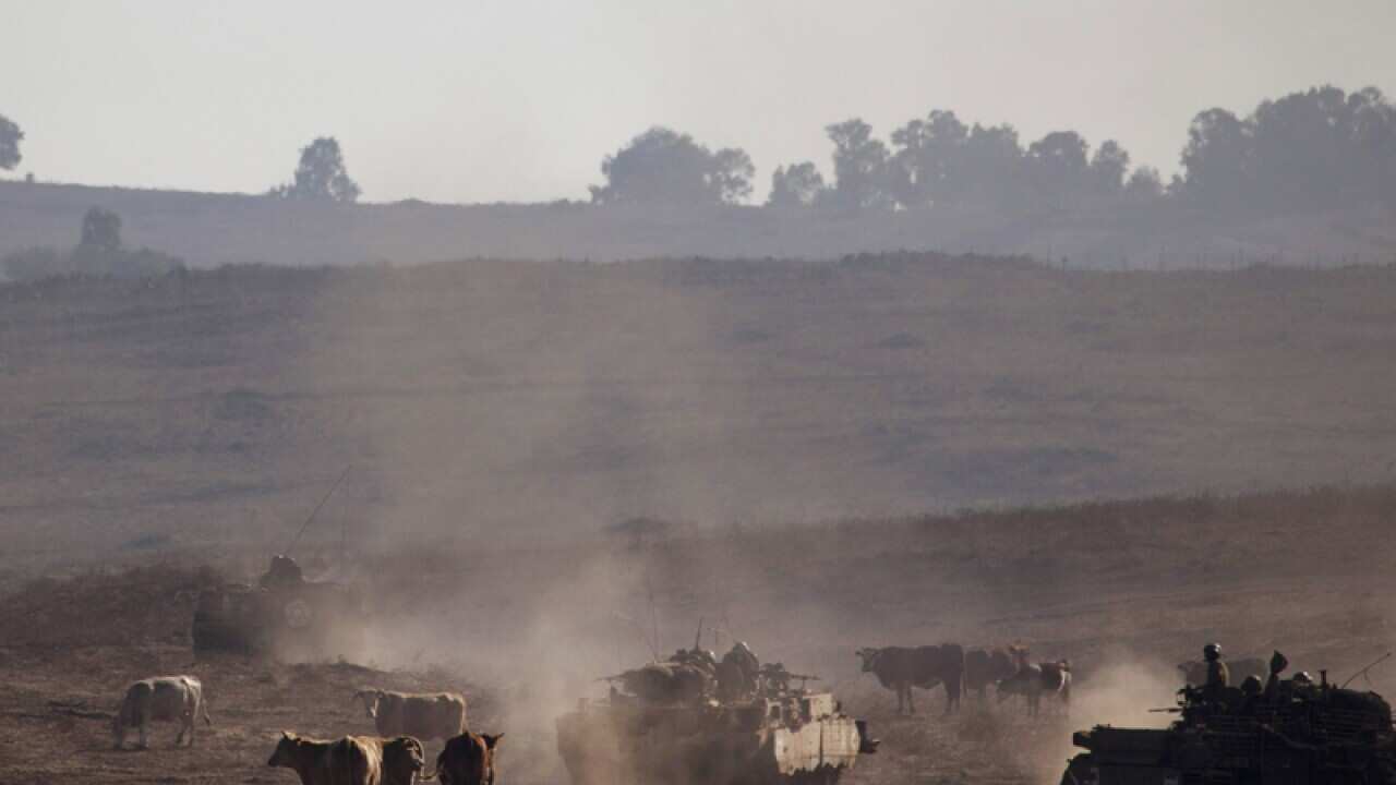 Israeli soldiers drive armoured vehicles in the Golan Heights