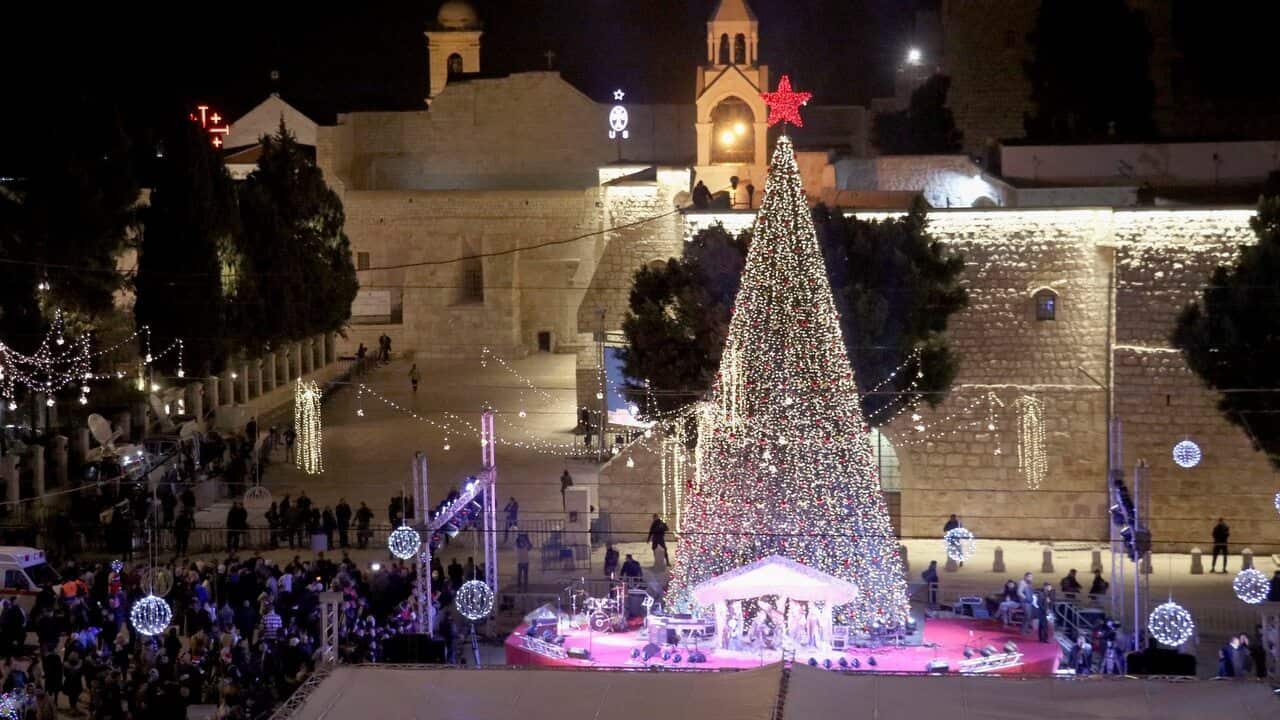 People gather around a Christmas tree near the Church of the Nativity in Bethlehem.