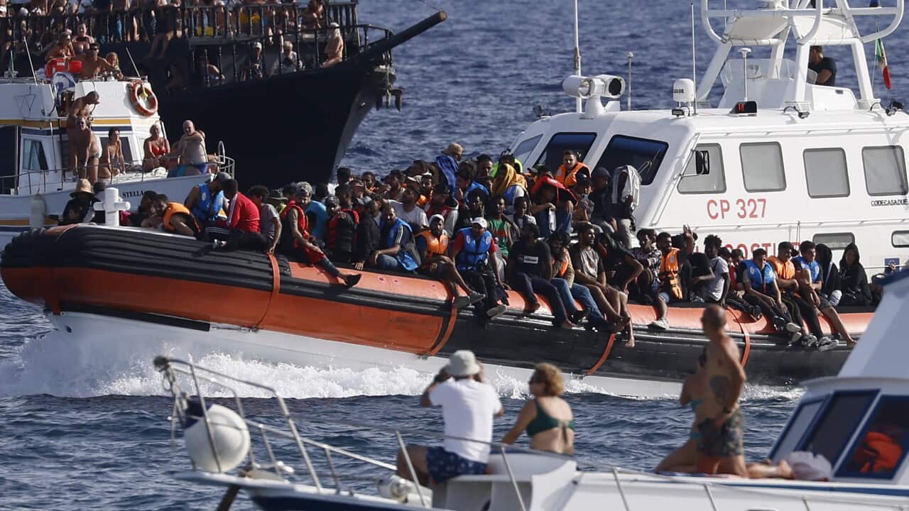 An Italian Coast Guard boat carries migrants near the island of Lampedusa