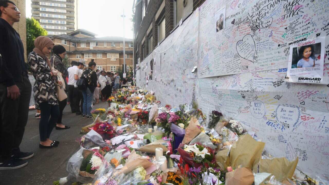 People look at tributes near Grenfell Tower in west London