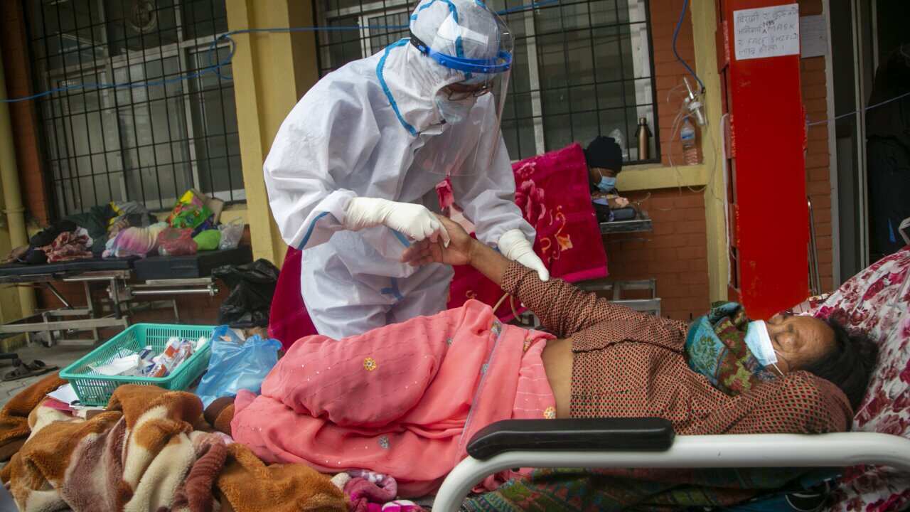 Nepalese paramedics treat a COVID-19 patient outside an emergency ward of a government run hospital in Kathmandu, Nepal, Monday, May 10, 2021. (AP Photo/Niranjan Shrestha)