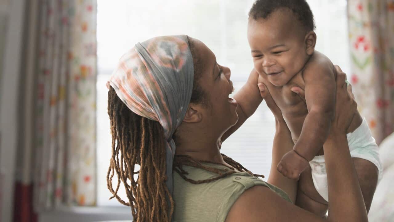 Black mother lifting baby son