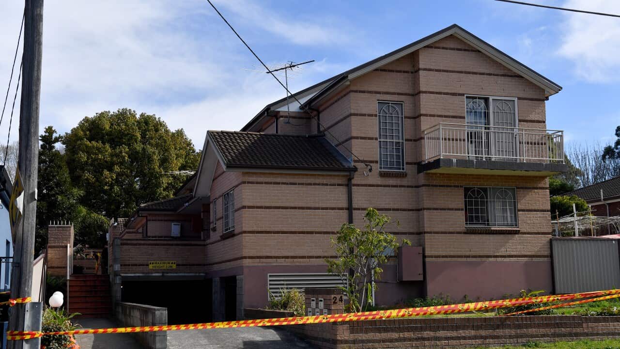A pink two-storey unit with HAZMAT tape in front of it