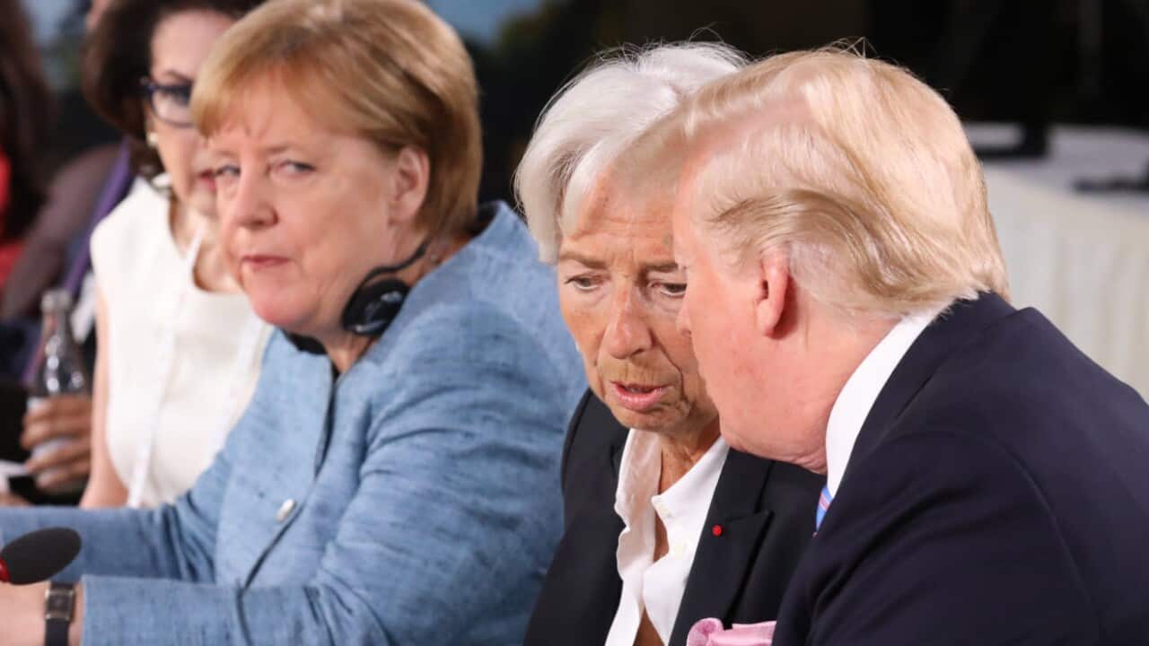 President Donald J. Trump (R) speaks with International Monetary Fund Managing Director Christine Lagarde (C) watched by German Chancellor Angela Merkel