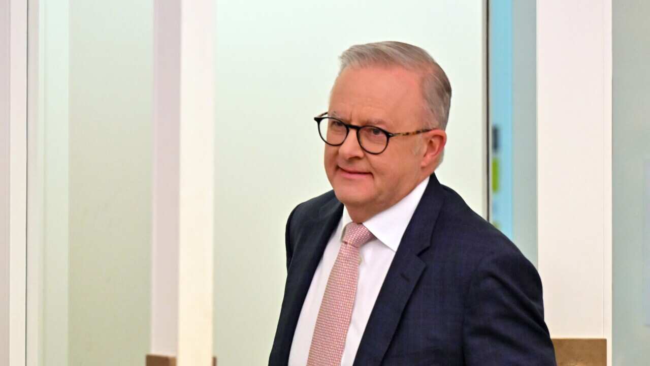 Anthony Albanese walks through a door