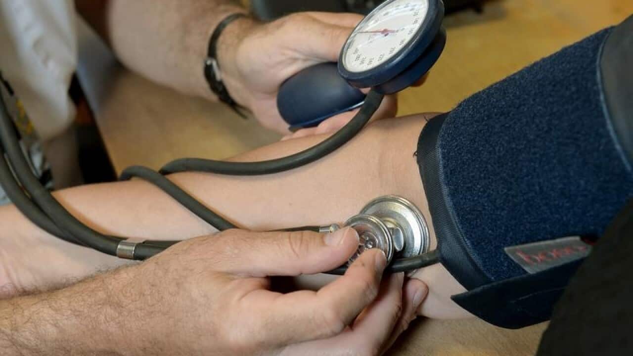 Dr Laurence Buckman checks a patient's blood pressure