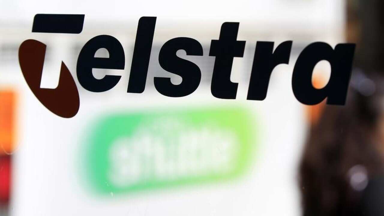 The Telstra name is painted on the side of a phone booth.