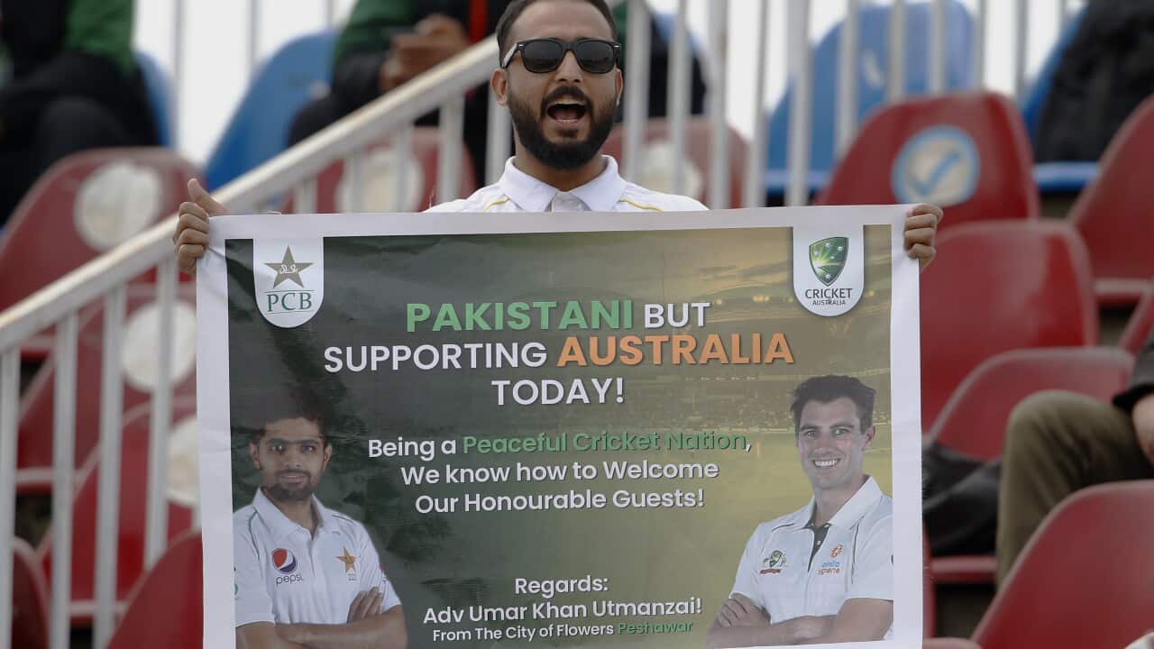 A cricket fan cheers with a poster during the 3rd day of the first cricket test match between Pakistan and Australia at the Pindi Stadium, in Rawalpindi, Pakistan, Sunday, March 6, 2022. (AP Photo/Anjum Naveed)