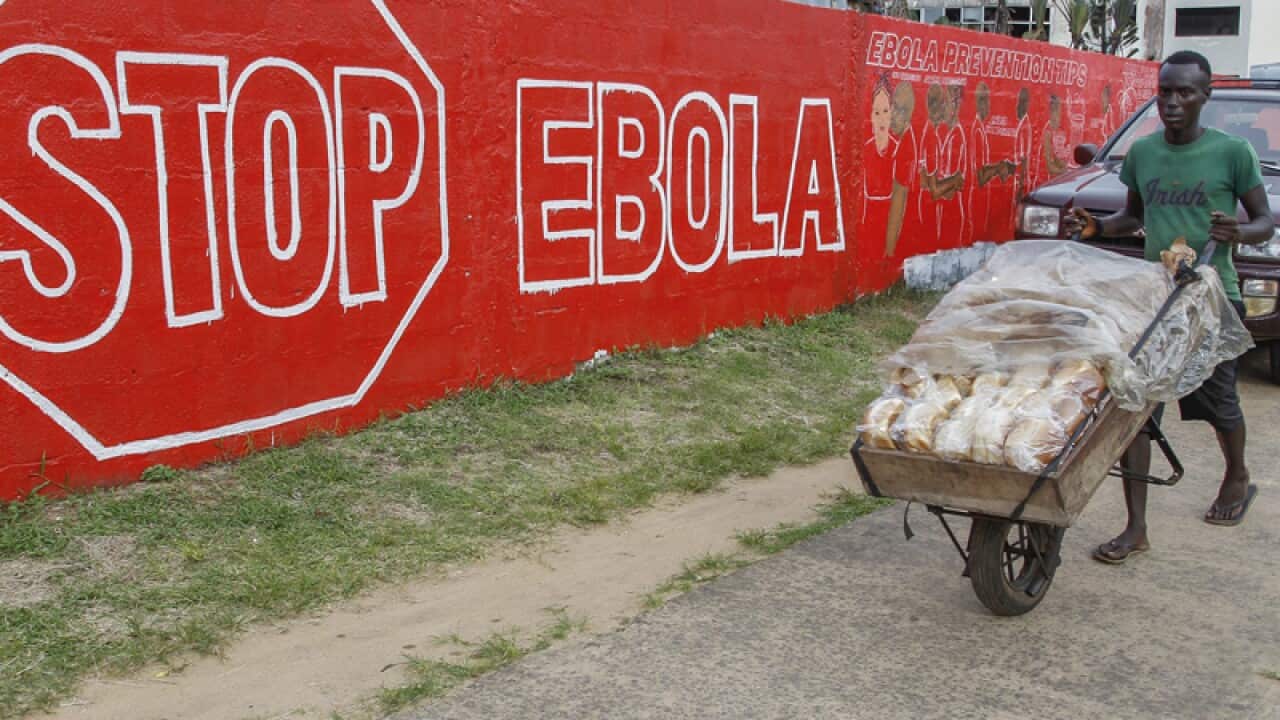 A man walks by a 'Stop Ebola' in Liberia.