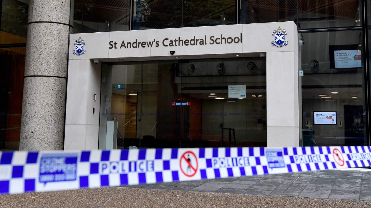Police tape outside a building entrance that has the sign St Andrew's Cathedral School above it