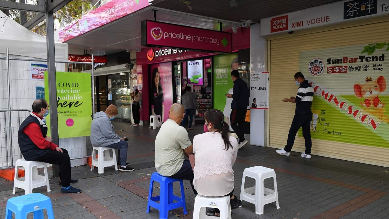 People are seen waiting to receive a Covid vaccination at a pharmacy in Cabramatta, south west of Sydney (AAP Image/Dan Himbrechts)