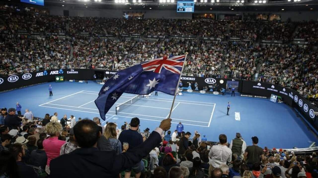A spectator waves an Australian flag at the Australian Open.