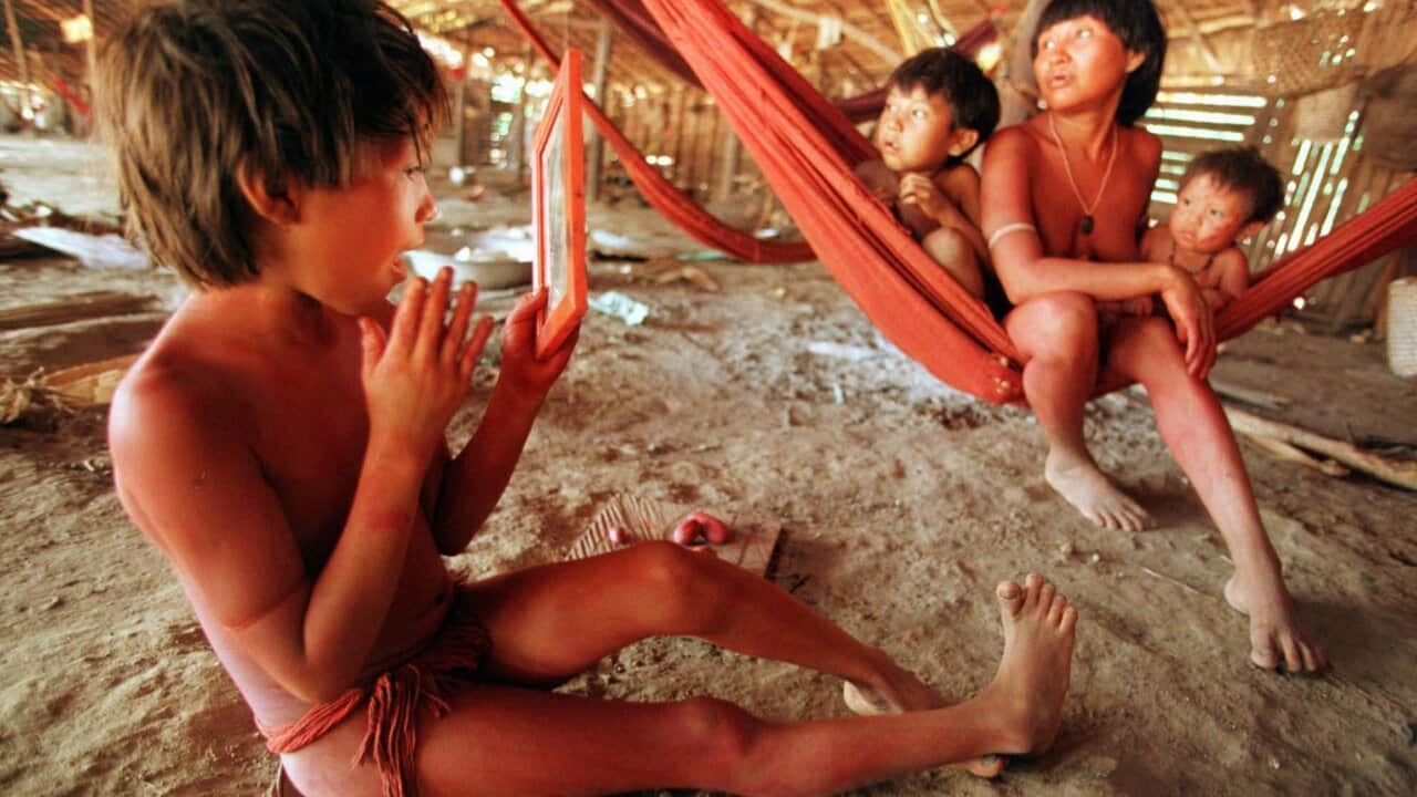 A Yanomami Indian child paints his face in the village of Demini in the Amazon Jungle, Brazil (AAP0