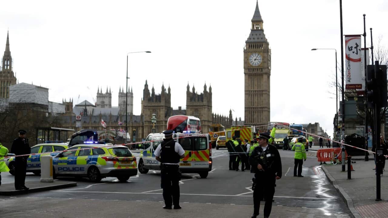 British police officers walk within a cordoned off area after an attack in the London Bridge area